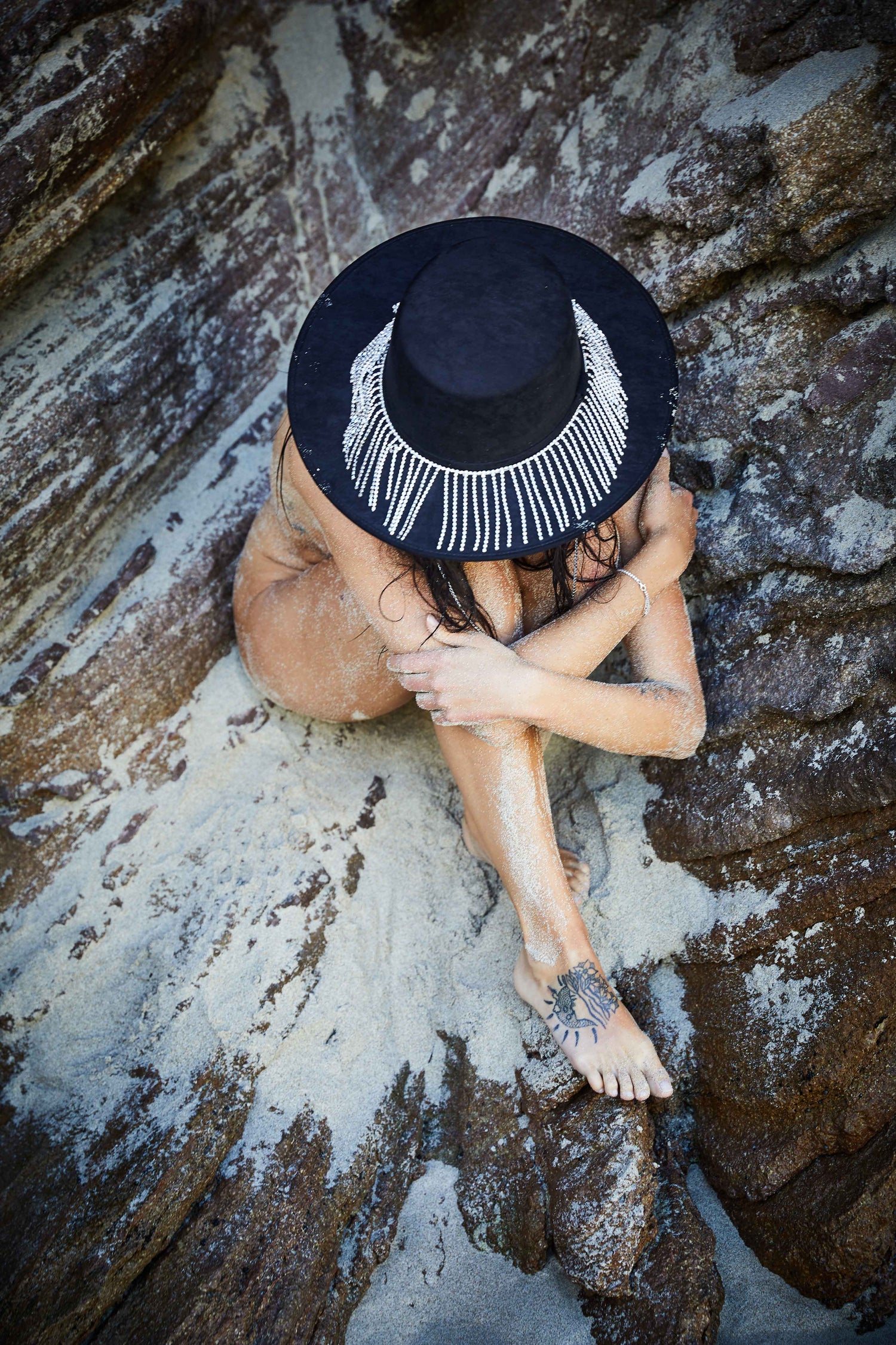 Chapeau noir personnalisé sur la plage. Un style envoûtant au bord de l'océan. My Sombrero, votre élégance intemporelle.